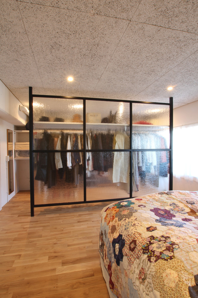 Design ideas for a modern storage and wardrobe in Tokyo with open cabinets, light hardwood floors and beige floor.