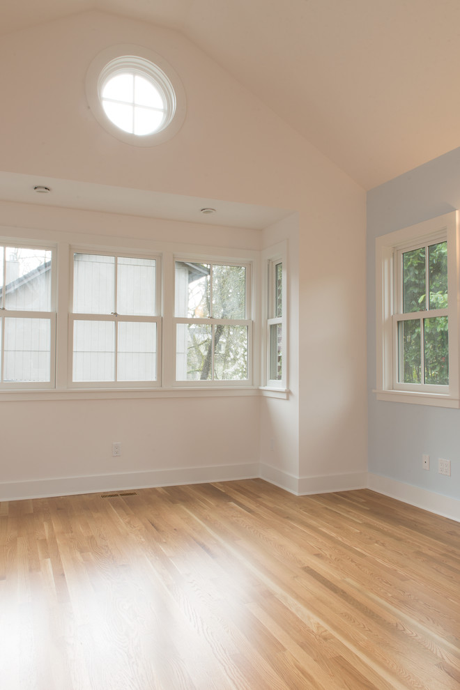 Photo of a traditional master bedroom in Portland with blue walls and medium hardwood floors.