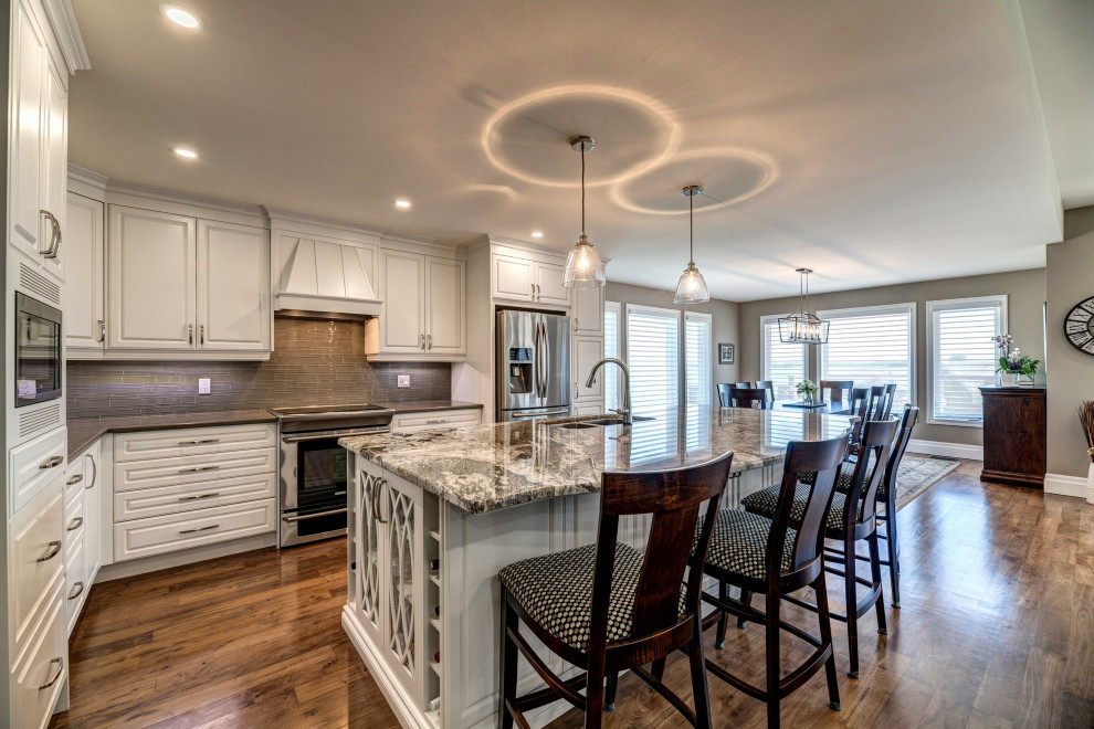 Transitional kitchen photo with white cabinets and an island