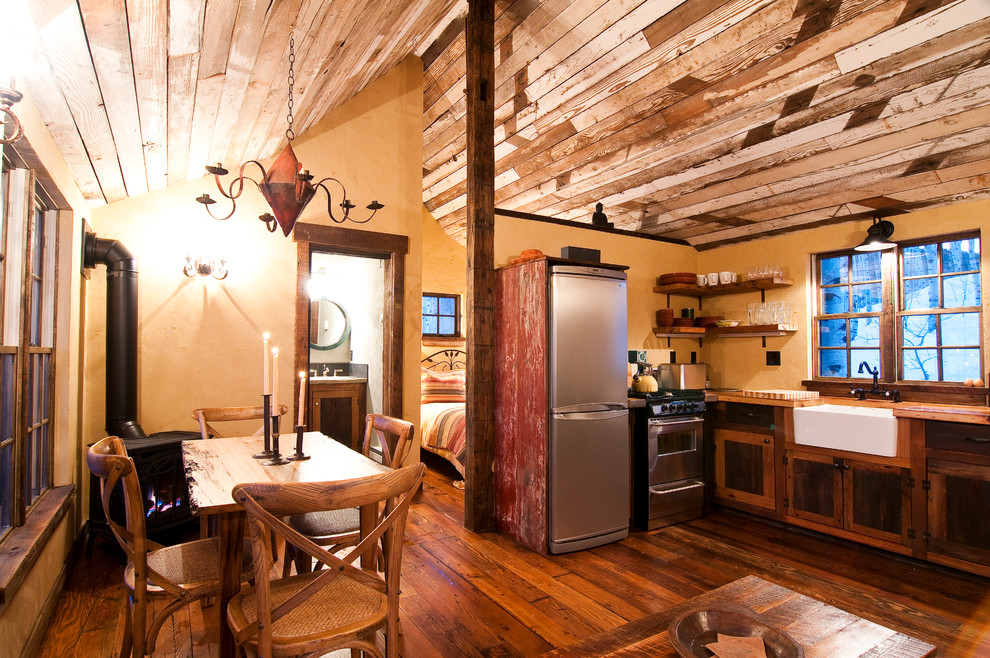 Inspiration for a small rustic dining room remodel in Denver with yellow walls
