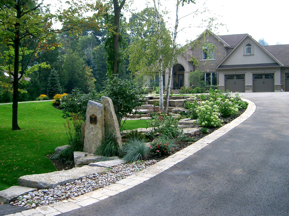 Large traditional front yard full sun driveway in Toronto with brick pavers.