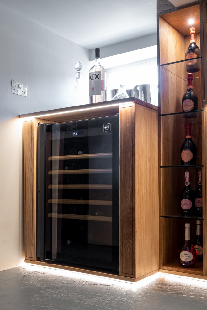 This is an example of a large classic wine cellar in Essex with grey floors.