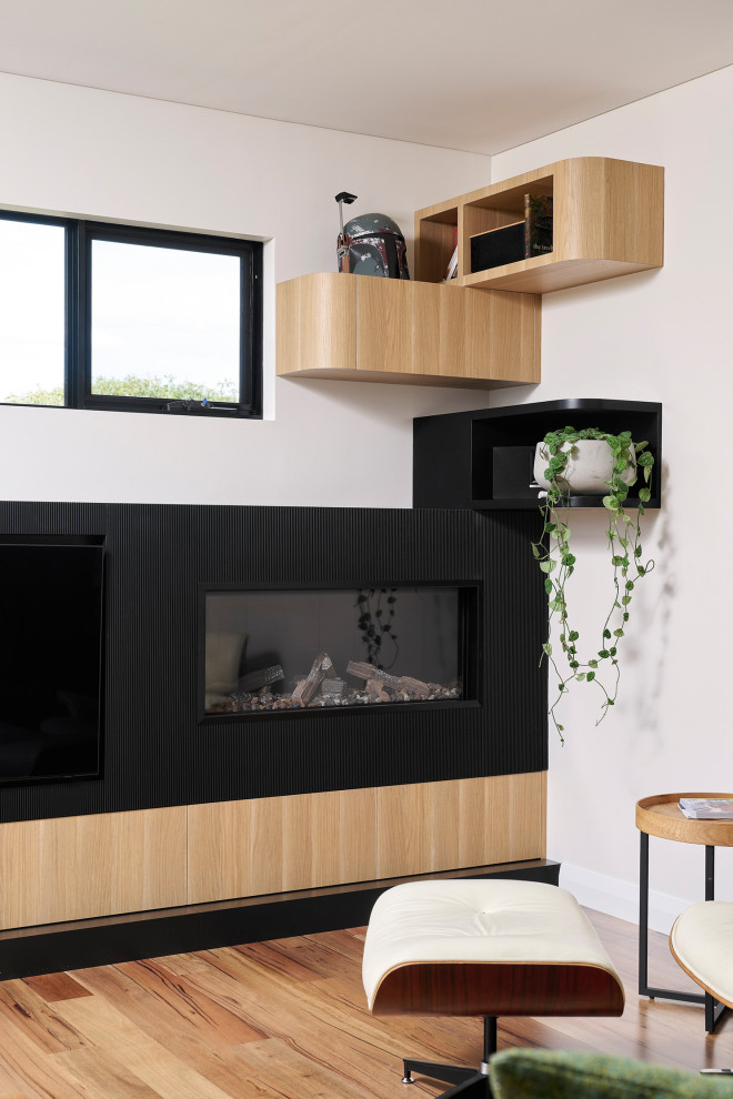 This is an example of a medium sized scandinavian formal open plan living room in Perth with white walls, medium hardwood flooring, a standard fireplace, a wooden fireplace surround, a built-in media unit and brown floors.