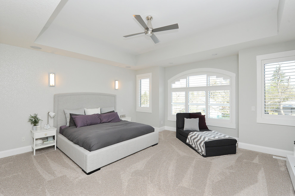 Large modern master bedroom in Calgary with grey walls, carpet, no fireplace and beige floor.