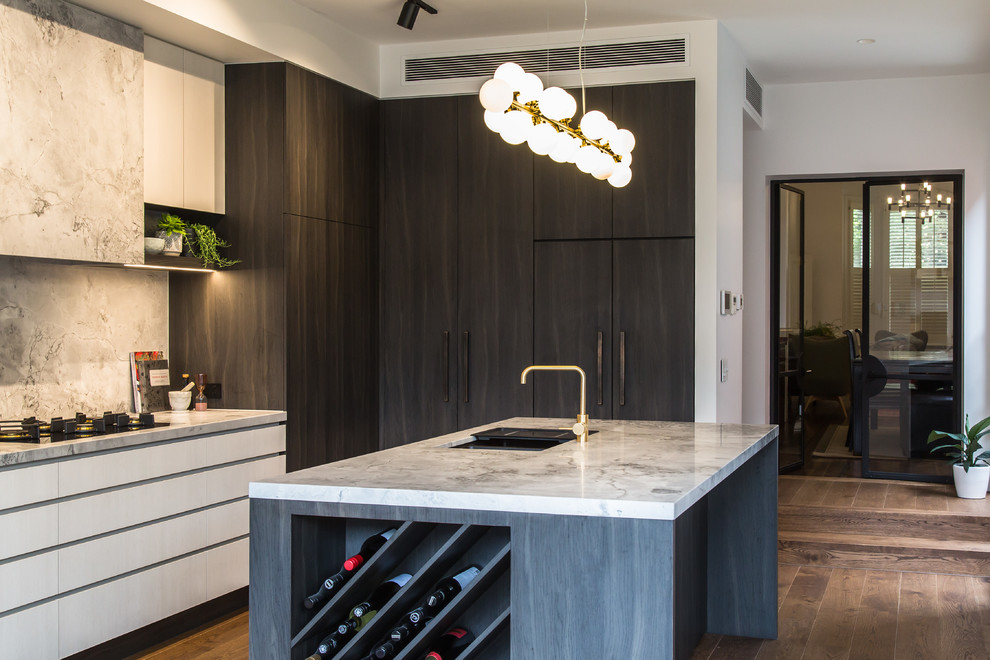 Contemporary l-shaped kitchen in Melbourne with an undermount sink, flat-panel cabinets, grey cabinets, grey splashback, panelled appliances, dark hardwood floors, with island, brown floor and white benchtop.