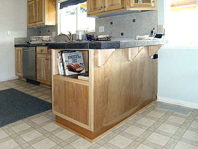 Kitchen - galley white floor kitchen idea with raised-panel cabinets, stainless steel appliances, a peninsula and gray countertops
