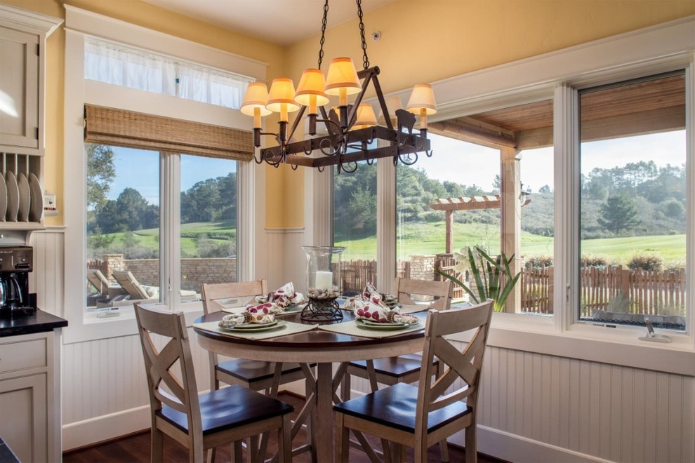 Mid-sized country kitchen/dining combo in San Luis Obispo with yellow walls and dark hardwood floors.