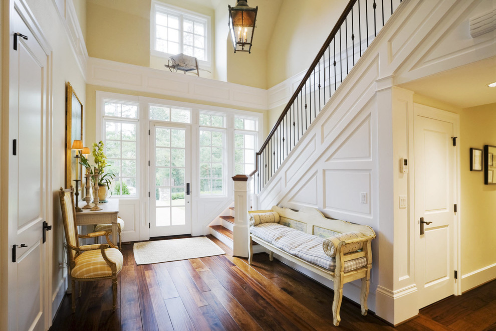 Inspiration for a mid-sized transitional dark wood floor and brown floor foyer remodel in Albuquerque with yellow walls and a white front door
