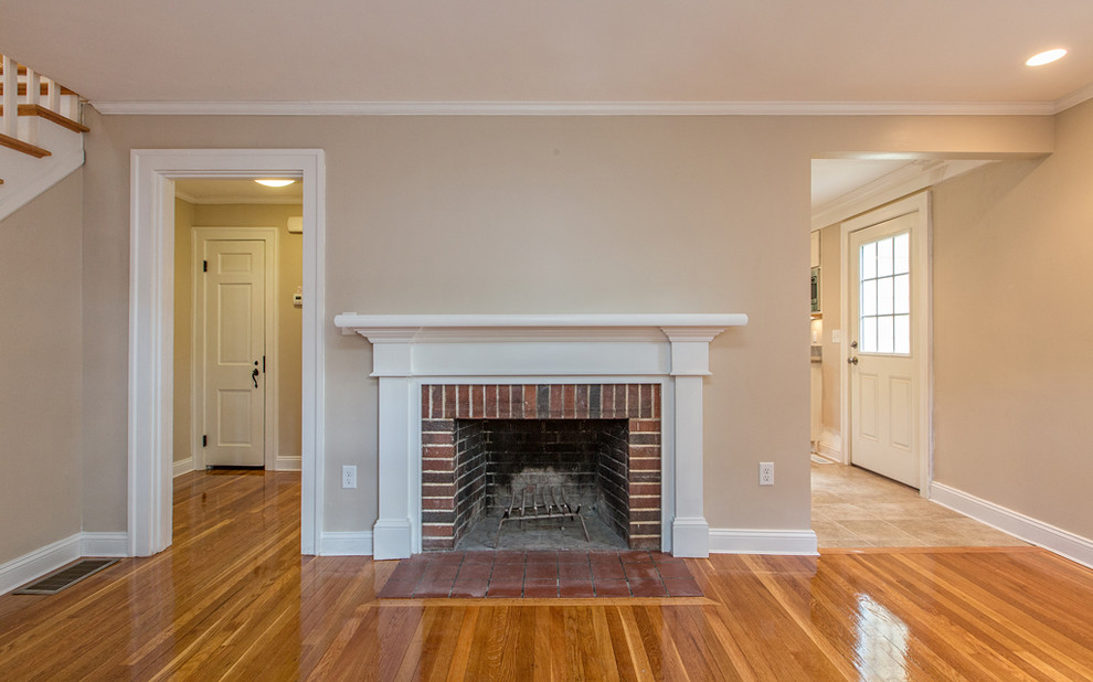Mid-sized traditional formal enclosed living room in Boston with grey walls, light hardwood floors, a standard fireplace, a brick fireplace surround, no tv and beige floor.