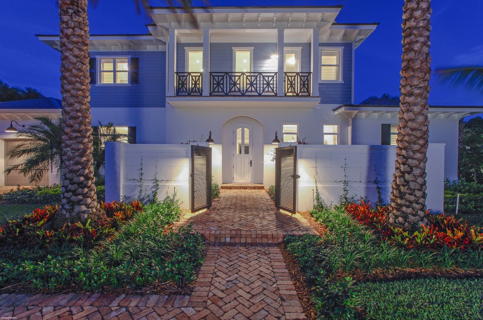 This is an example of a mid-sized transitional two-storey stucco white exterior in Miami with a flat roof.