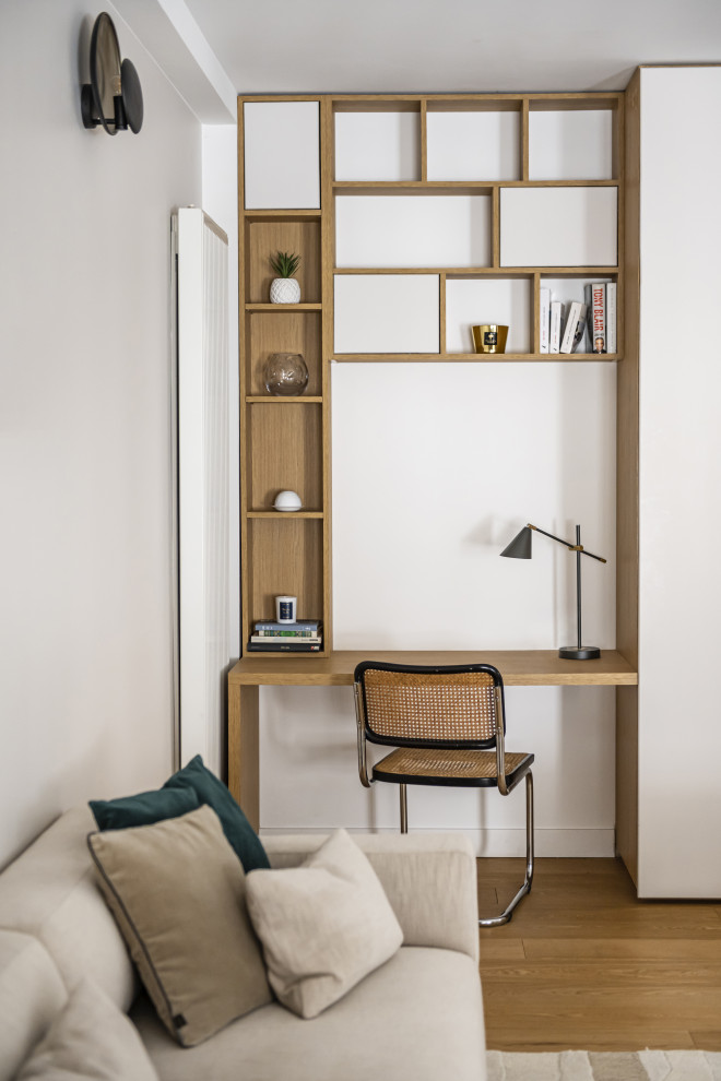 Inspiration för mellanstora moderna hemmabibliotek, med beige väggar, ljust trägolv, brunt golv, ett bibliotek och ett fristående skrivbord