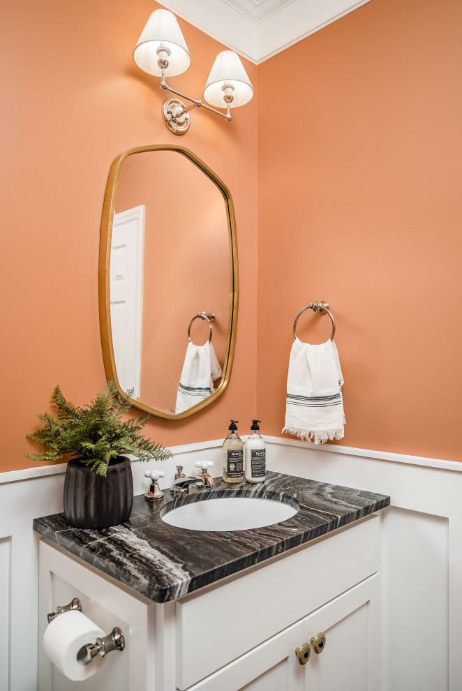 Design ideas for a small transitional powder room in Charlotte with shaker cabinets, white cabinets, orange walls, an undermount sink, marble benchtops, black benchtops, a built-in vanity and decorative wall panelling.