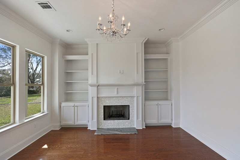 This is an example of a traditional open concept family room in New Orleans with beige walls, a standard fireplace and a tile fireplace surround.