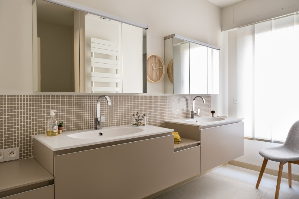 Exemple d'une salle de bain tendance avec un placard à porte plane, des portes de placard grises, un carrelage beige, mosaïque, un mur beige, un lavabo intégré, un sol gris, un plan de toilette blanc, meuble double vasque et meuble-lavabo suspendu.