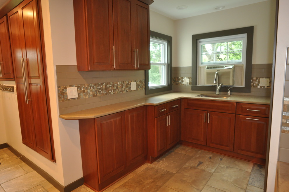 Example of a kitchen design in Chicago with stainless steel appliances and beige countertops