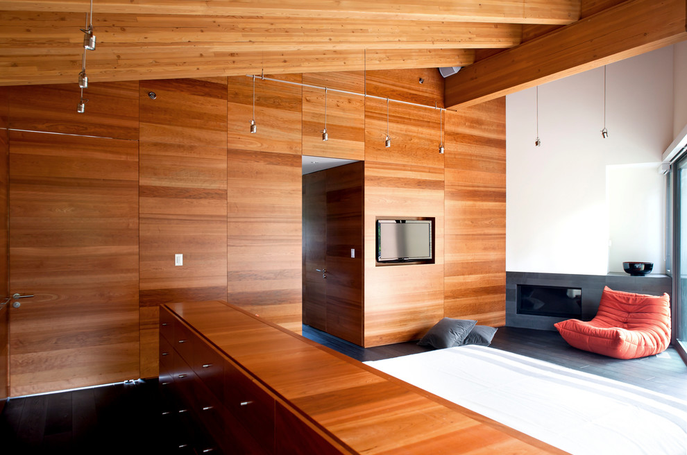 Photo of a modern bedroom in Vancouver with a ribbon fireplace.