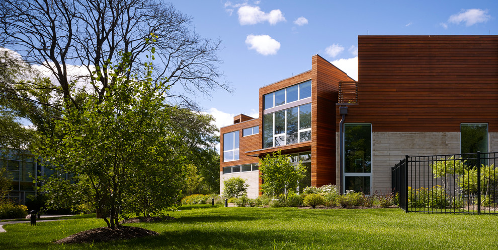 Huge trendy multicolored two-story wood flat roof photo in Chicago