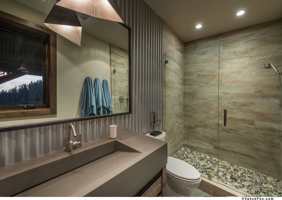 Rustik inredning av ett mellanstort badrum med dusch, med släta luckor, skåp i mellenmörkt trä, en dusch i en alkov, grå kakel, keramikplattor, grå väggar, betonggolv, ett avlångt handfat, bänkskiva i betong, grått golv och dusch med gångjärnsdörr