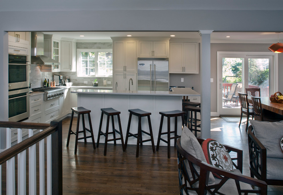Open concept kitchen - transitional l-shaped open concept kitchen idea with an undermount sink, shaker cabinets, white cabinets, quartz countertops, gray backsplash, porcelain backsplash and stainless steel appliances