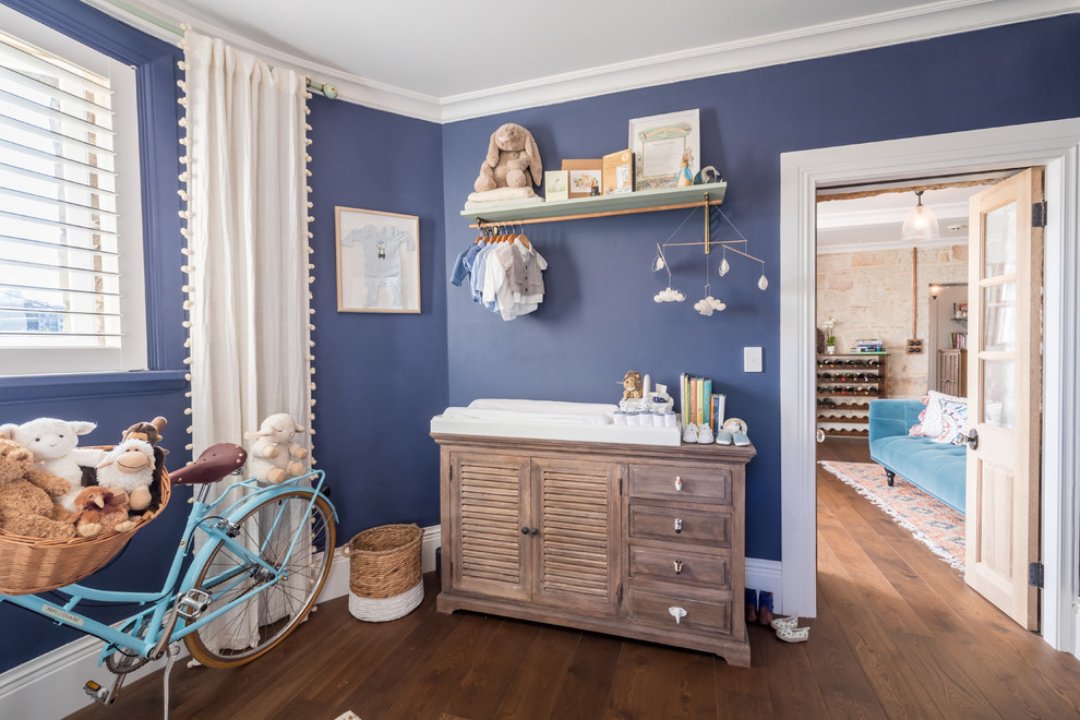 Design ideas for a mid-sized transitional nursery for boys in Sydney with blue walls, dark hardwood floors and brown floor.