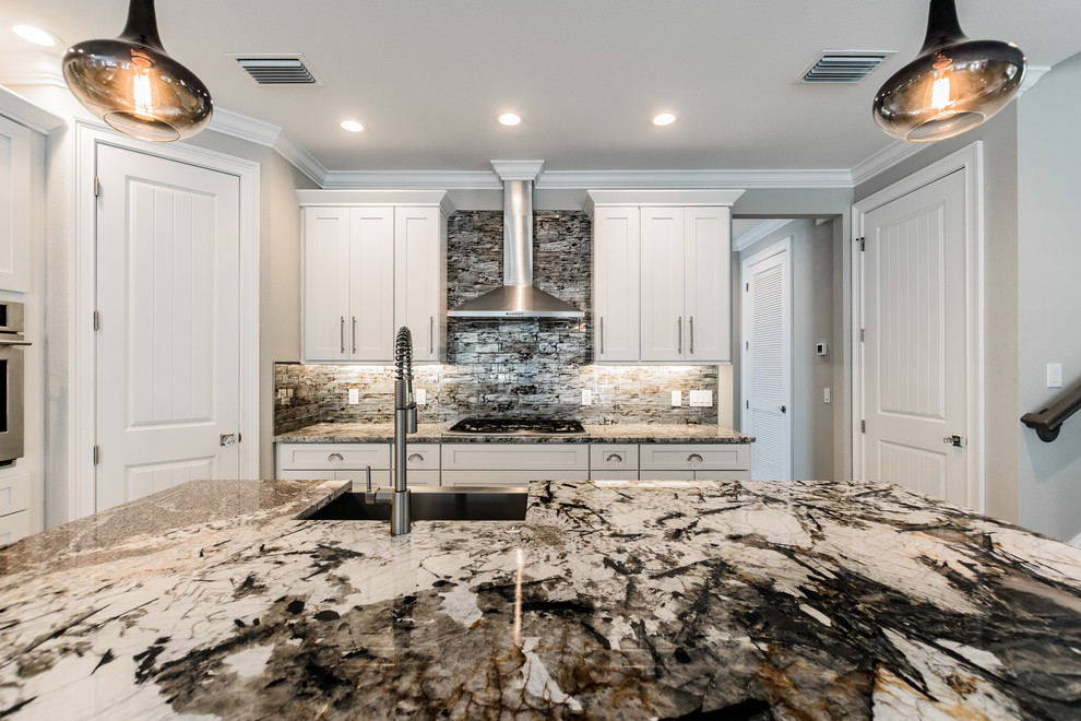 Inspiration for a mid-sized eclectic l-shaped eat-in kitchen in Tampa with an undermount sink, shaker cabinets, white cabinets, onyx benchtops, glass tile splashback and with island.