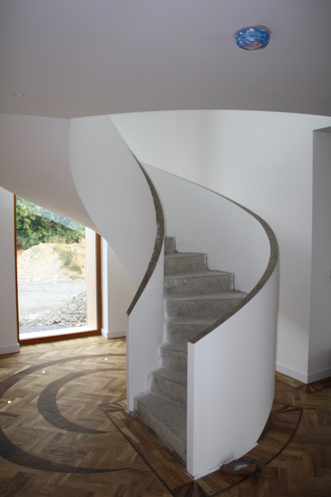 Inspiration for a mid-sized contemporary concrete curved staircase in Other with concrete risers.