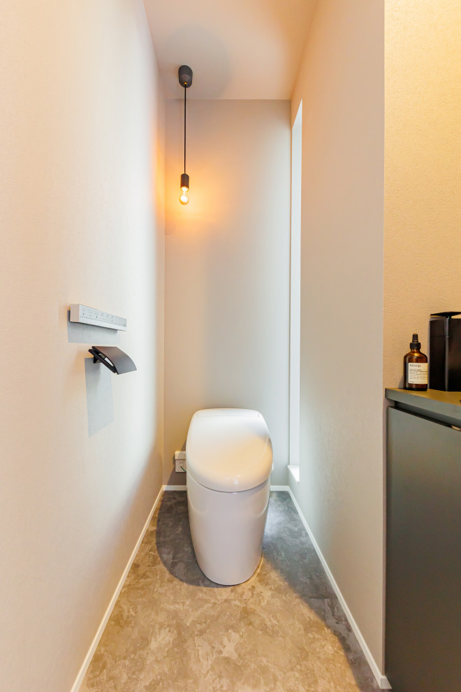 Mittelgroße Moderne Gästetoilette mit flächenbündigen Schrankfronten, weißen Fliesen, brauner Waschtischplatte, freistehendem Waschtisch, Tapetendecke und Tapetenwänden in Kobe