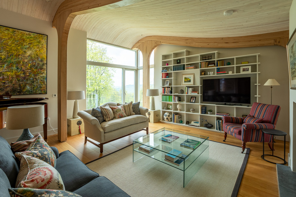 Design ideas for a traditional open plan living room with grey walls, medium hardwood flooring, a standard fireplace, a freestanding tv, brown floors, exposed beams, a vaulted ceiling and a wood ceiling.