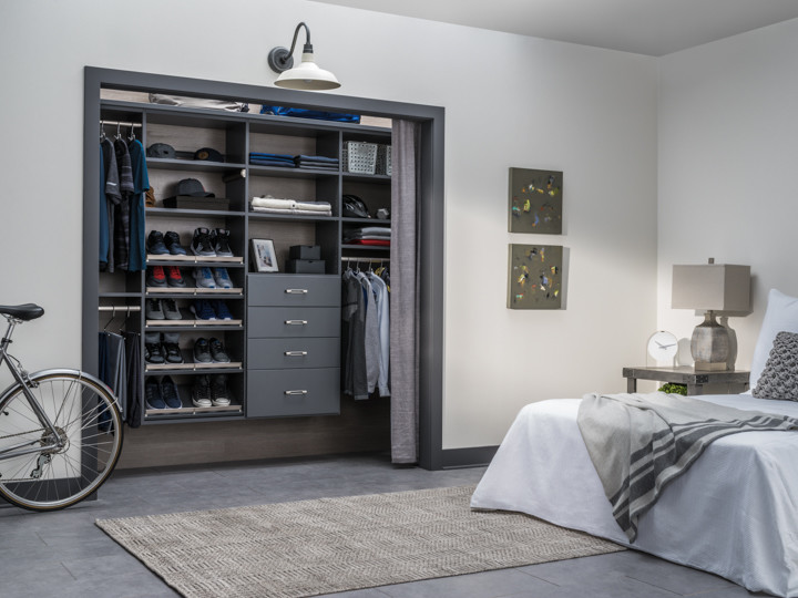 Inspiration for a small contemporary gender-neutral concrete floor and gray floor reach-in closet remodel in New Orleans with open cabinets and gray cabinets