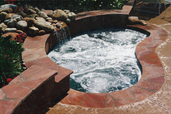 Photo of a mid-sized traditional backyard kidney-shaped lap pool in San Diego with a hot tub and concrete slab.