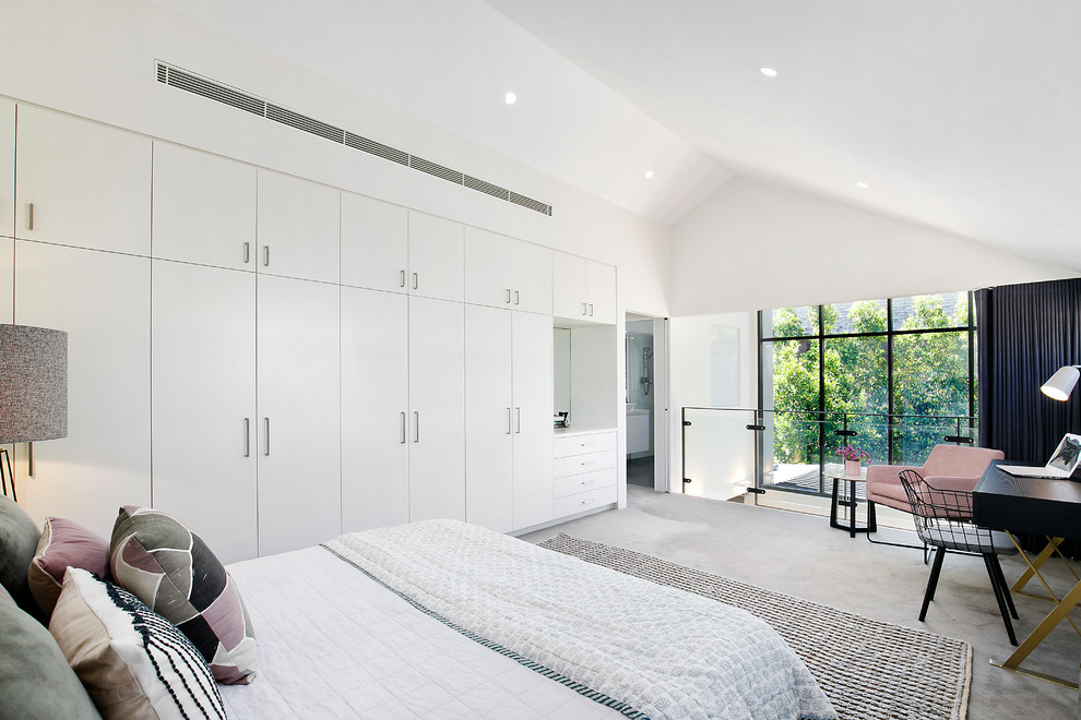 This is an example of a contemporary loft-style bedroom in Sydney with white walls, carpet, no fireplace and grey floor.