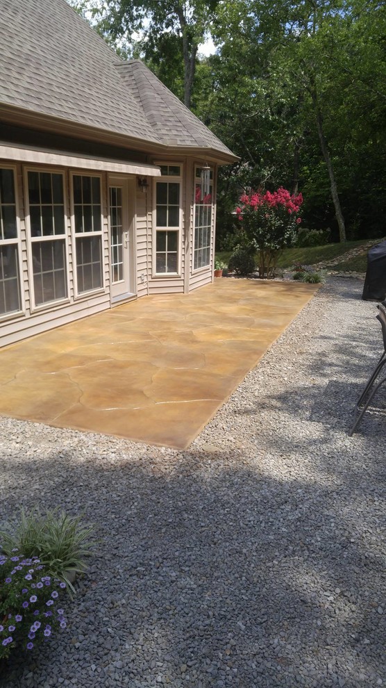 Photo of a mid-sized traditional backyard patio in Other with stamped concrete and no cover.