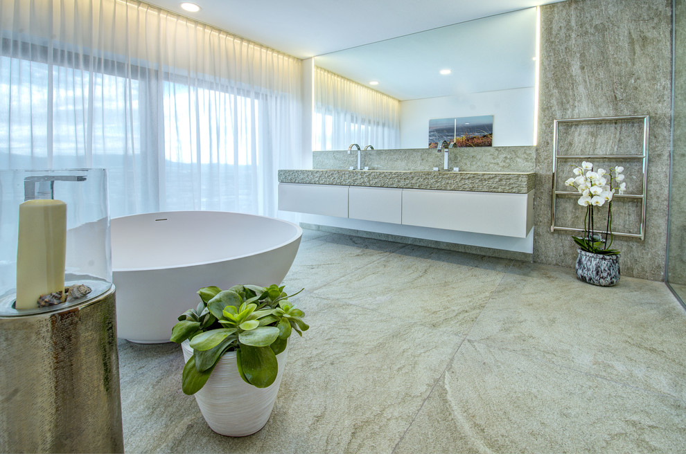 Ispirazione per una stanza da bagno padronale design di medie dimensioni con vasca freestanding, piastrelle verdi, lastra di pietra, lavabo rettangolare, top in quarzite e pavimento verde