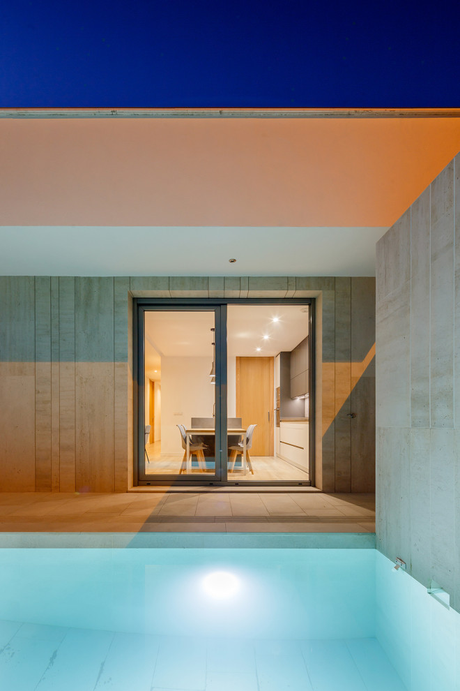 Immagine di una piscina monocorsia minimal rettangolare di medie dimensioni e nel cortile laterale con paesaggistica bordo piscina e piastrelle