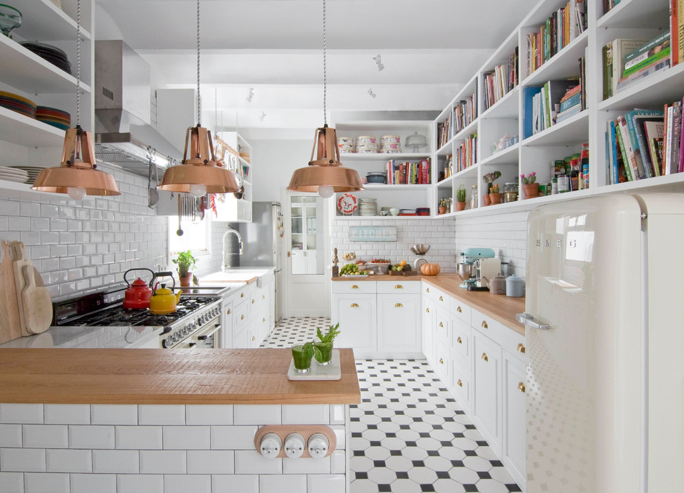 This is an example of a large eclectic galley separate kitchen in Barcelona with recessed-panel cabinets, white cabinets, wood benchtops, white splashback, subway tile splashback, white appliances, ceramic floors and a peninsula.