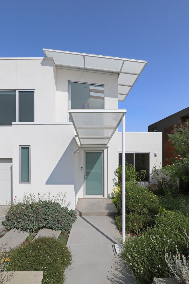 Foto de fachada de casa blanca y blanca moderna de tamaño medio de dos plantas con tejado de un solo tendido y tejado de varios materiales