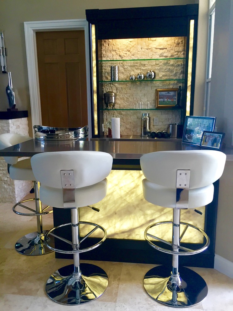 This is an example of a mid-sized transitional l-shaped wet bar in Miami with open cabinets, black cabinets, stainless steel benchtops, beige splashback, stone tile splashback, porcelain floors and beige floor.