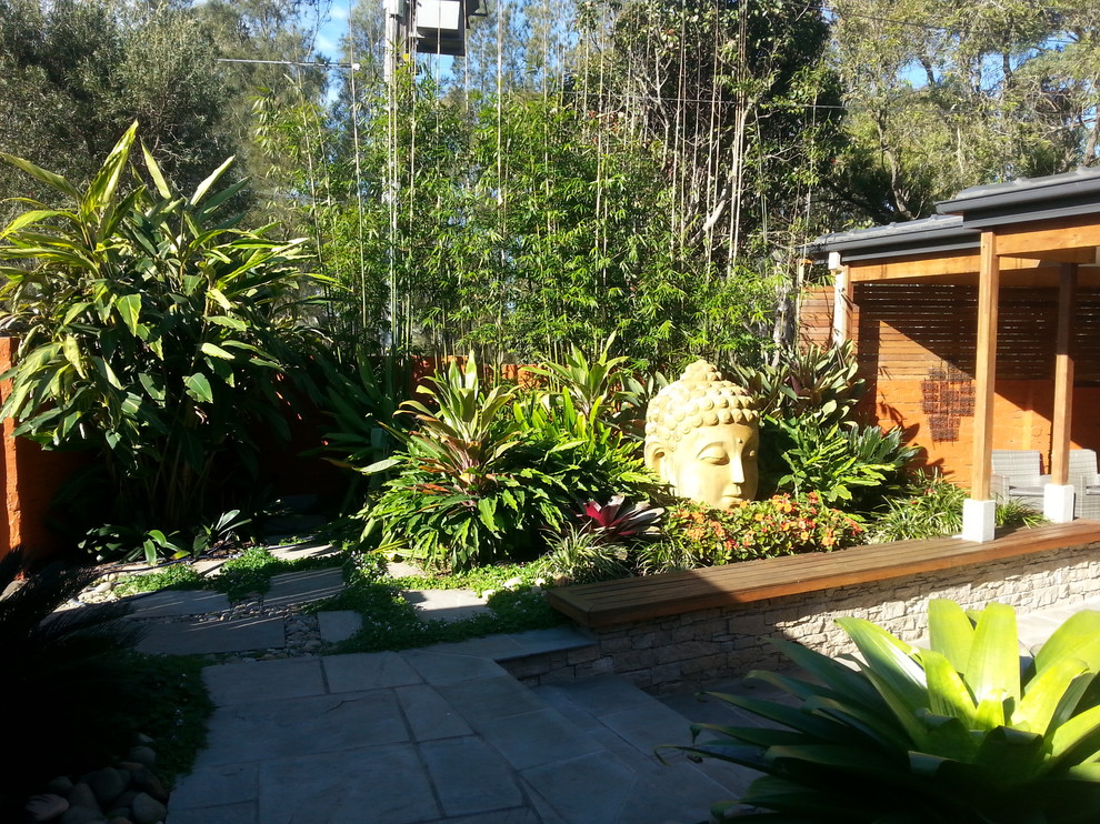 Photo of a tropical drought-tolerant backyard stone landscaping in Sydney.