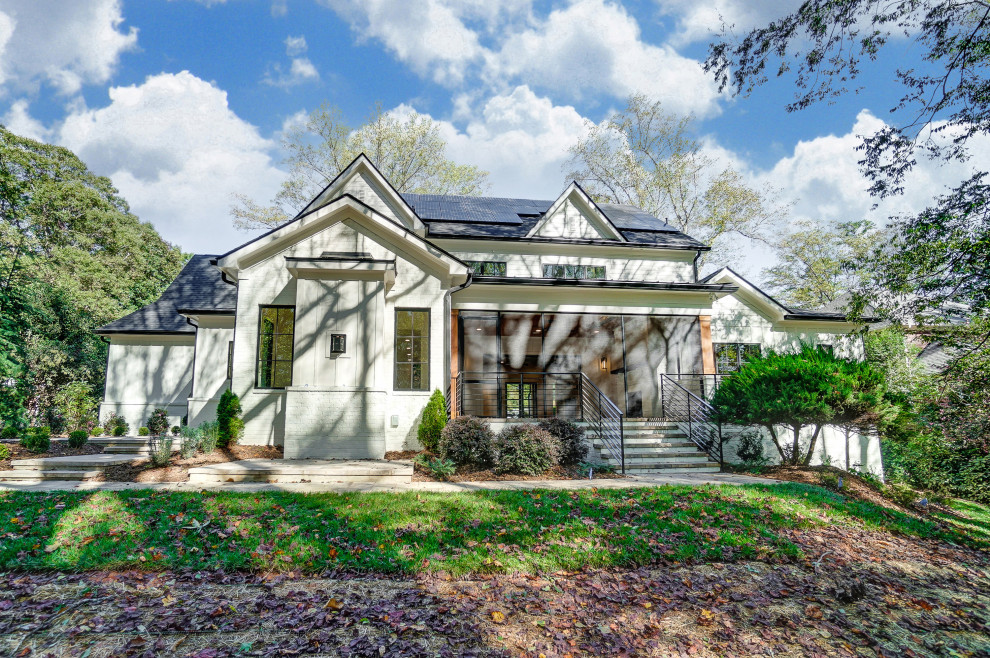 Großes, Zweistöckiges Country Einfamilienhaus mit gestrichenen Ziegeln, weißer Fassadenfarbe, Satteldach, Schindeldach, schwarzem Dach und Wandpaneelen in Charlotte