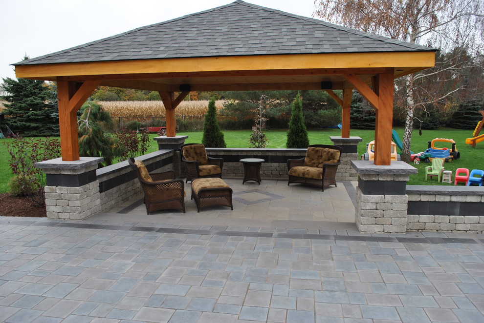 Inspiration for a large arts and crafts backyard patio in Toronto with a fire feature, natural stone pavers and a gazebo/cabana.