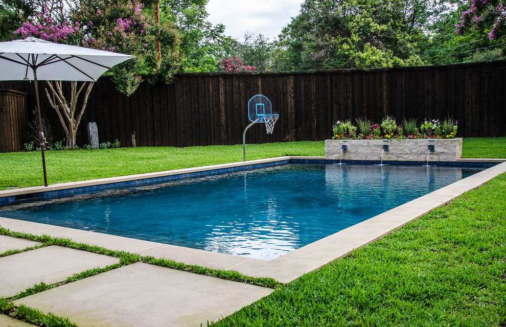 Example of a mid-sized transitional backyard rectangular pool fountain design in Dallas with decking