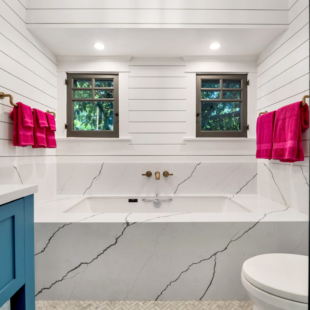 Источник вдохновения для домашнего уюта: большая главная ванная комната в стиле модернизм с фасадами в стиле шейкер, синими фасадами, накладной ванной, угловым душем, унитазом-моноблоком, белыми стенами, полом из керамической плитки, накладной раковиной, столешницей из кварцита, серым полом, душем с распашными дверями, белой столешницей, тумбой под одну раковину, напольной тумбой и панелями на части стены