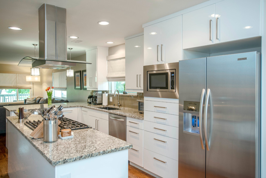 Inspiration for a mid-sized transitional l-shaped light wood floor eat-in kitchen remodel in Denver with an undermount sink, flat-panel cabinets, white cabinets, granite countertops, beige backsplash, subway tile backsplash, stainless steel appliances and an island