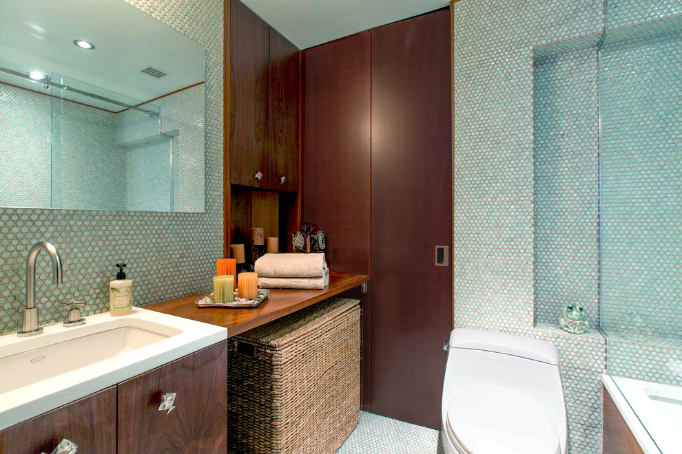 Mid-sized contemporary master bathroom in New York with an undermount sink, flat-panel cabinets, medium wood cabinets, wood benchtops, a drop-in tub, a shower/bathtub combo, a one-piece toilet, blue tile, mosaic tile, blue walls and mosaic tile floors.