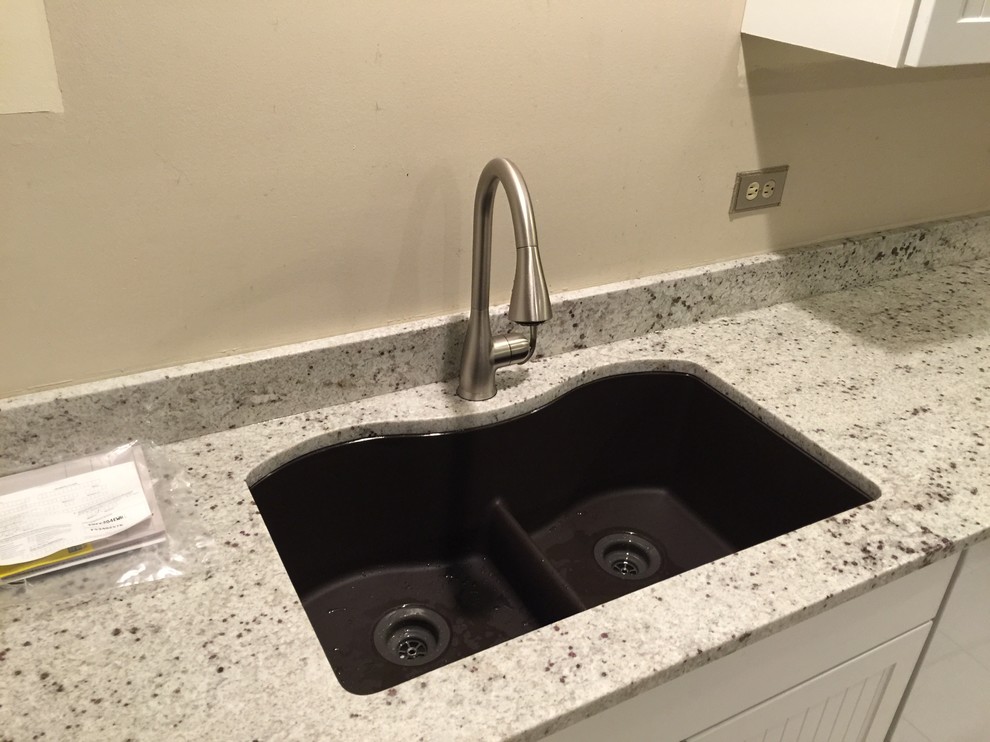 Inspiration for a mid-sized transitional l-shaped ceramic tile enclosed kitchen remodel in Chicago with an undermount sink, flat-panel cabinets, white cabinets, granite countertops, white appliances and an island