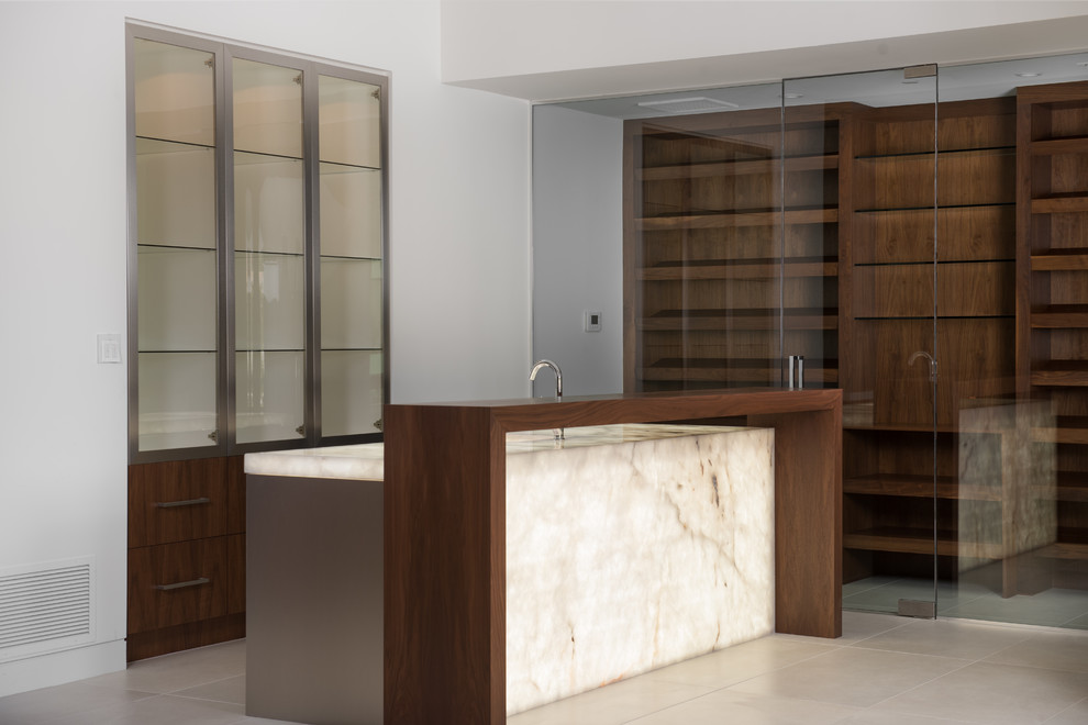 Design ideas for a mid-sized contemporary single-wall wet bar in Phoenix with an integrated sink, flat-panel cabinets, medium wood cabinets, onyx benchtops, porcelain floors and beige floor.