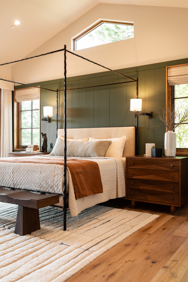 Example of a mountain style medium tone wood floor, brown floor, vaulted ceiling and wainscoting bedroom design in Phoenix with beige walls