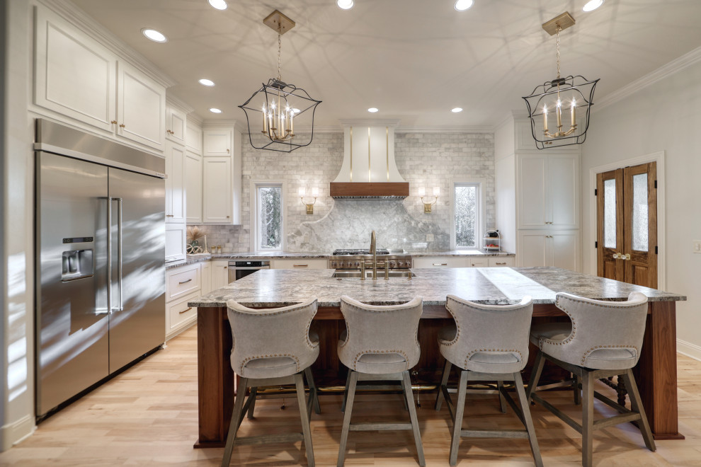 Design ideas for a large eclectic l-shaped eat-in kitchen in Nashville with a farmhouse sink, beaded inset cabinets, white cabinets, granite benchtops, grey splashback, marble splashback, stainless steel appliances, with island and grey benchtop.