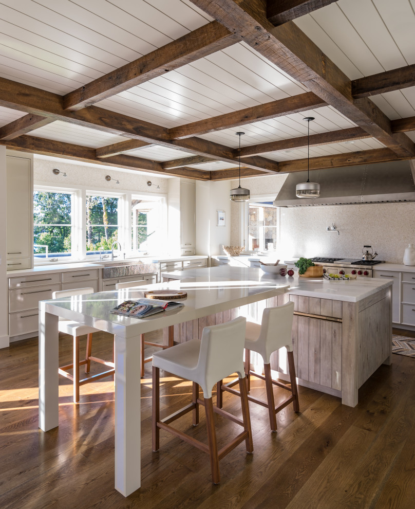 Beach style eat-in kitchen in Boston with a farmhouse sink, flat-panel cabinets, grey cabinets, stainless steel appliances, dark hardwood floors, with island, brown floor and white benchtop.