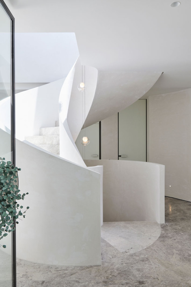 Design ideas for an expansive modern spiral staircase in Melbourne with limestone treads and limestone risers.